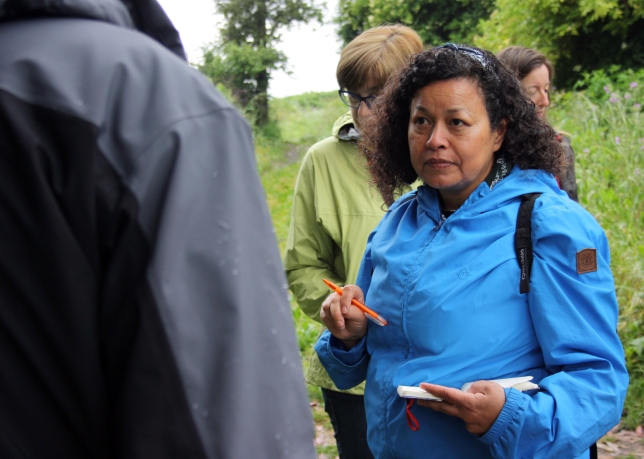 Marlene Anaya escoita o que conta o biólogo César López durante a camiñada